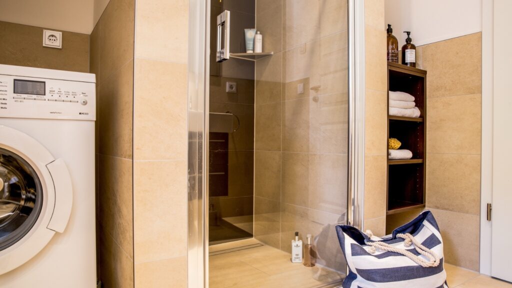 Bad mit Dusche und Waschmaschine in strandnaher Ferienwohnung