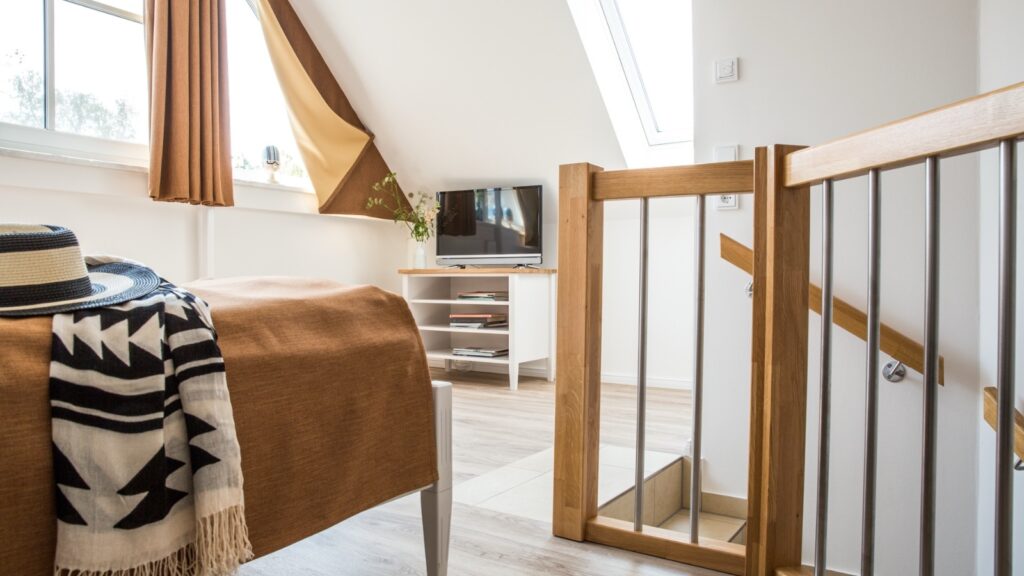 Schlafzimmer mit zwei Fenstern und TV in strandnaher Ferienwohnung in Zingst